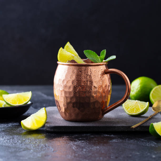 istock Moscow Mules cocktail with ginger beer, vodka, lime and mint. Grey background. Close up. 1265944693