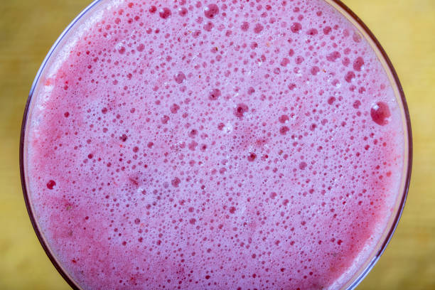 istock Pink strawberry shake on the yellow background, closeup, top view 1265944764
