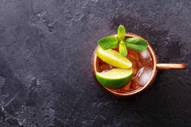 istock Moscow Mules cocktail with ginger beer, vodka, lime and mint. Grey background. Copy space. Top view. 1265944843