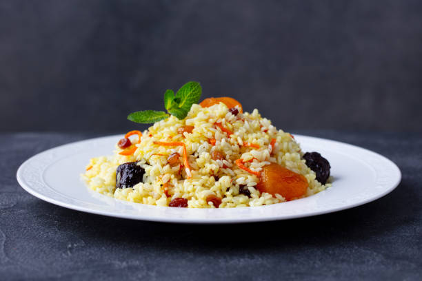 pilaf, plov con frutos secos y azafrán. fondo oscuro. de cerca. - dried apricot close up gourmet dried fruit fotografías e imágenes de stock