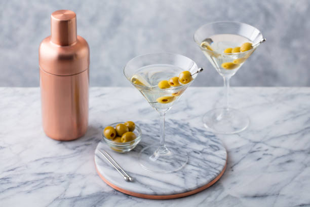 istock Martini cocktail with olives and bar shaker on marble table background. Close up. 1265950218