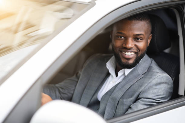 istock Happy successful black businessman looking through car window 1265951950