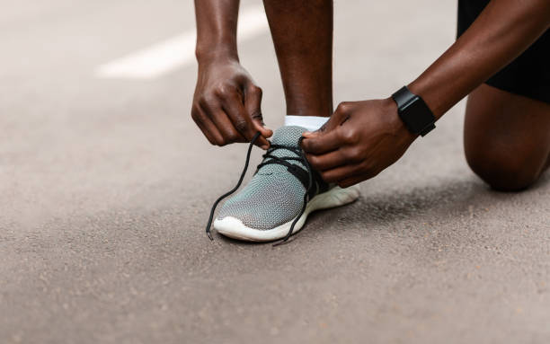 istock Closeup of black guy tying his shoelaces before jogging 1265956187