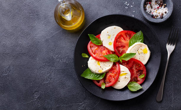 ensalada caprese con tomates, queso mozzarella, albahaca. fondo oscuro. copiar espacio. vista superior. - salad mozzarella food balsamic vinegar fotografías e imágenes de stock