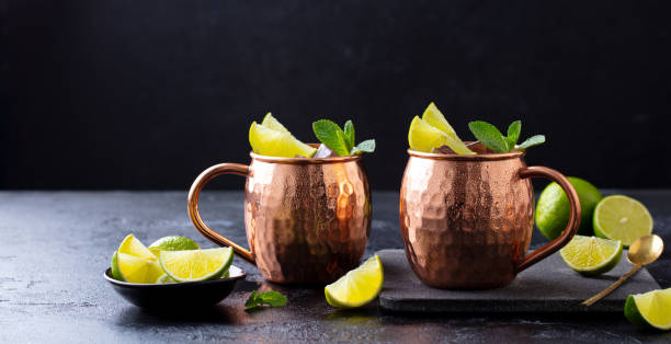 istock Moscow Mules cocktail with ginger beer, vodka, lime and mint. Grey background. Copy space. 1265957134