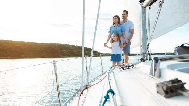 istock Family Embracing Standing On Yacht Relaxing On Weekend Outdoors, Panorama 1265957694