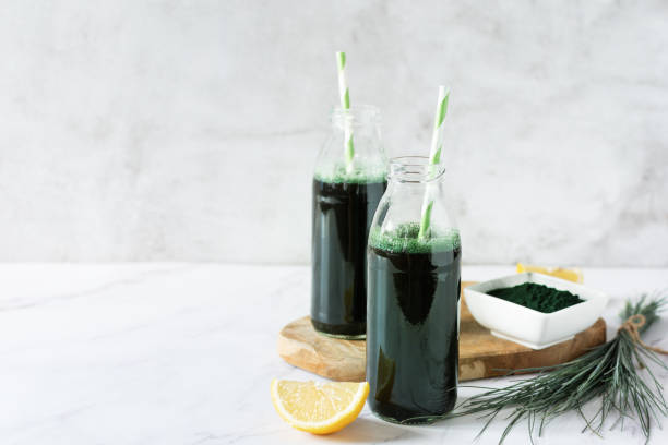 Spirulina drink with lemon and spirulina algae powder on white marble table. Spirulina drink with lemon and spirulina algae powder on white marble table. Superfood, detox drink. chlorella stock pictures, royalty-free photos & images