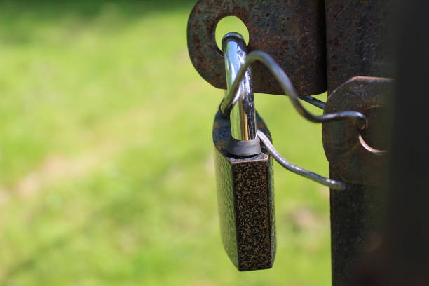 istock closed metal lock on iron gates, doors 1265959992