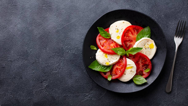 ensalada caprese con tomates, queso mozzarella, albahaca. fondo oscuro. copiar espacio. vista superior. - caprese salad salad restaurant vinegar fotografías e imágenes de stock