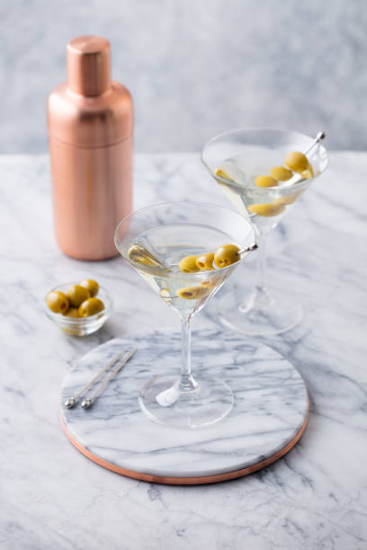 istock Martini cocktail with olives and bar shaker on marble table background. Close up. 1265964434