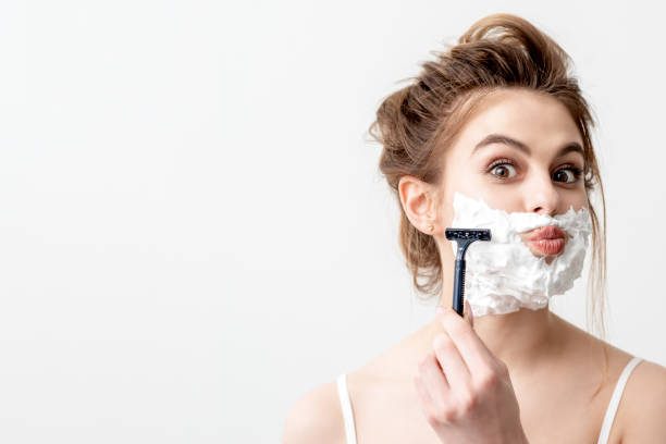 istock Woman shaving her face by razor 1265964830