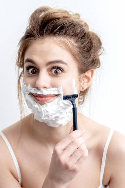istock Woman shaving her face by razor 1265964888