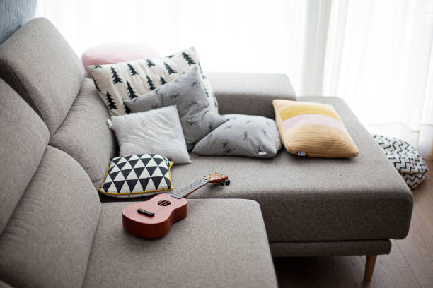 istock brown ukulele music instrument on a grey sofa and pillows 1265970879