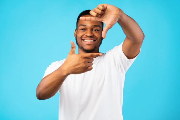 Smiling African Man Framing Face With Fingers On Blue Background