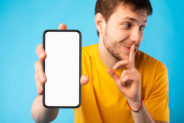 Happy man showing blank cellphone screen to camera