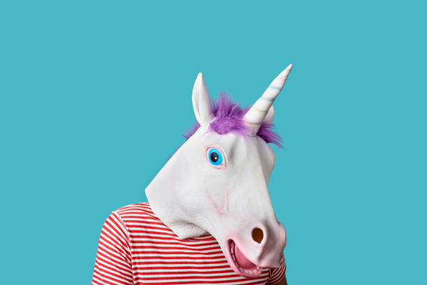 istock man wearing a unicorn mask on a blue background 1265974908