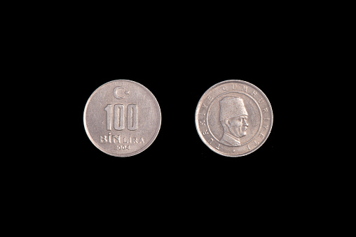 Turkish 100 Bin Liras Coins Isolated On black. close-up