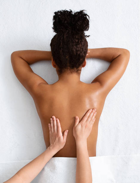 terapeuta masajeando mujer africana espalda, vista superior - massage therapist fotografías e imágenes de stock