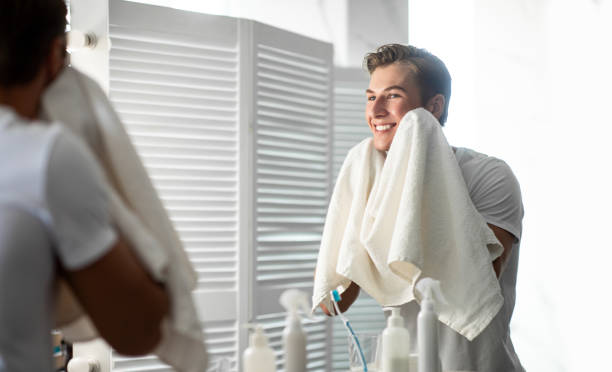 istock Confident man looking in the mirror with towel 1265986909