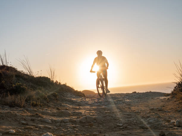 istock Mountain biker riding on the edge of a cliff at sunset 1265987480