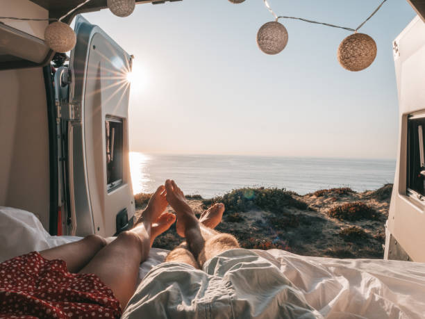 casal deitado na parte de trás de uma van olhando para o oceano, perspectiva pessoal - travel trailer - fotografias e filmes do acervo