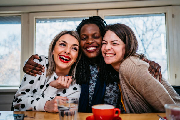 istock Three women friends embracing in cafe 1266010323