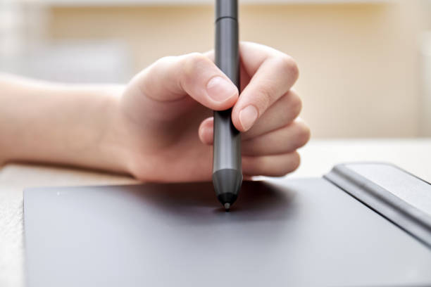 istock Girl draws on a graphics tablet with pen. Close-up, selective focus 1266010531