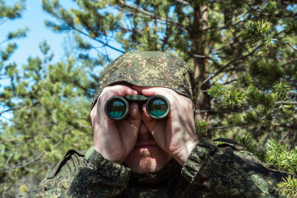 istock saboteur or scout secretly watches through binoculars 1266015987