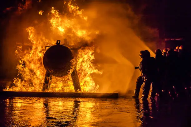 Photo of Firefighters extinguishing a fire at a storage tank