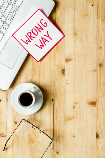 istock Wrong way icon on office desk - wooden, top view copy space 1266020588