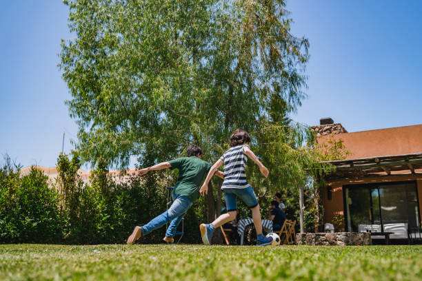 istock Kids playing football in backyard 1266022915