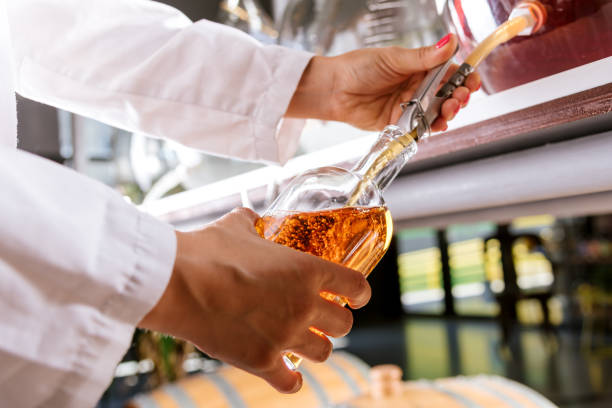 istock Pouring whiskey into a bottle 1266030012