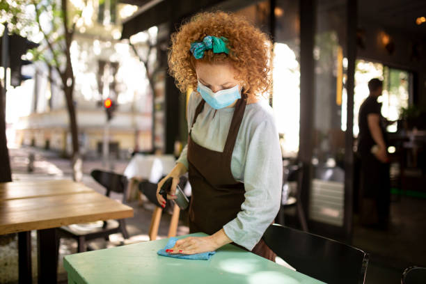 istock Young Caucasian female waitress cleaning the tables 1266031475