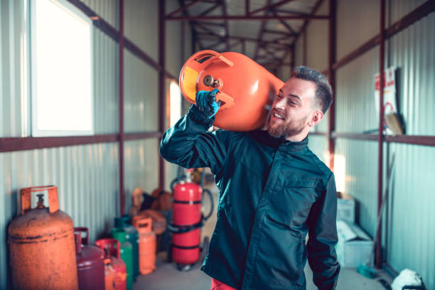 Smiling Male Carrying Gas Cylinder On Shoulder