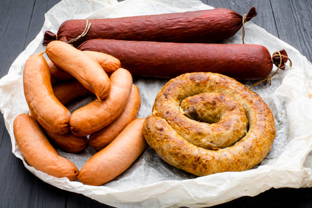 istock Different types of natural sausages on a wooden background. 1266032964