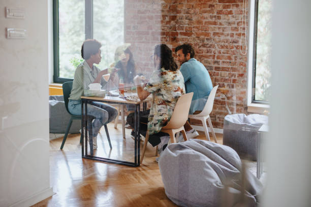 istock Coworkers talking through a screen partition at office cafeteria 1266044369