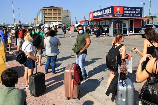 Greece, Piraeus, August 1 2020 - Passengers waiting for buying tickets and embarking on a ferry boat at the port of Piraeus, with Greek islands as destination.