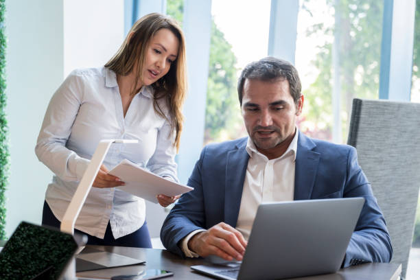 istock Hispanic business colleagues discussing data on laptop 1266054626