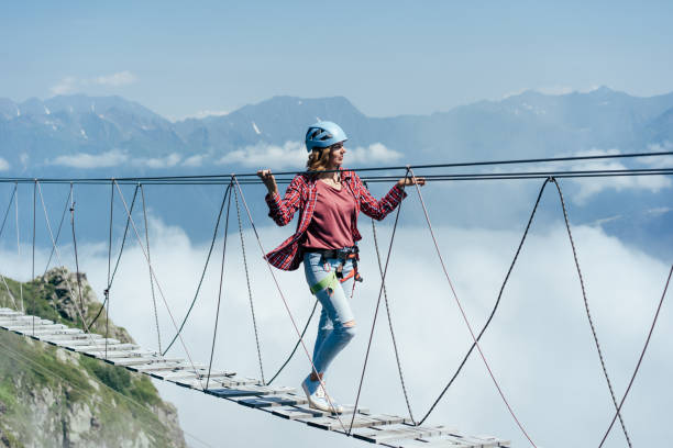 istock A woman walking on a rope bridge 1266059526
