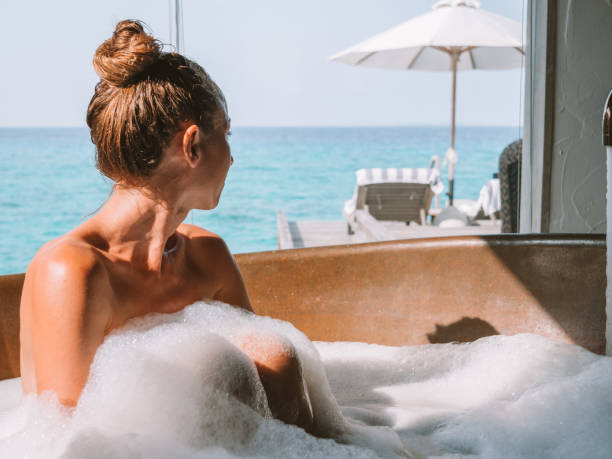 istock Young woman taking a bath in luxury villa over sea 1266061996