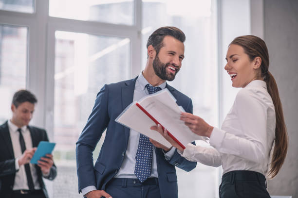 istock Laughing man and woman with documents in office 1266062308