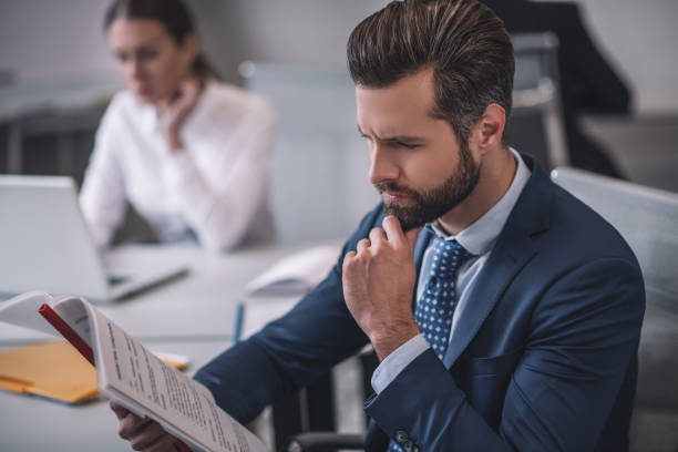 istock Business man attentively examining documents in office 1266062416