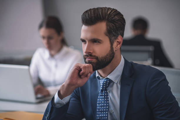 istock Attractive man in suit looking into the distance 1266062439