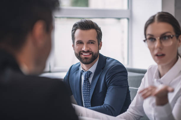 istock Gesturing serious woman, smiling man and colleague back 1266062461