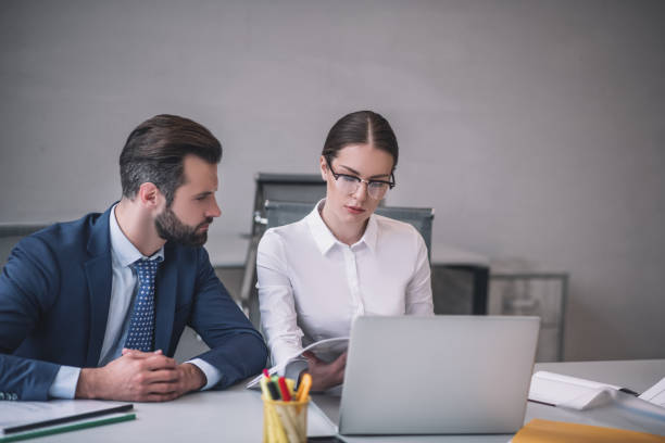 istock Bearded male and brown-haired female checking something on laptop 1266062465