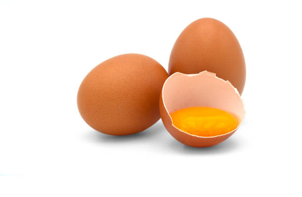 istock Two Eggs and a half of chicken egg with yolk in egg shell isolated on white background. 1266066637