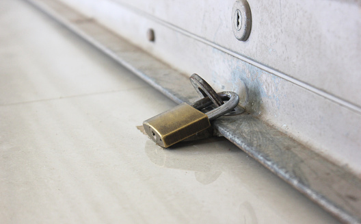 close up locks between the steel rolling shutters door and the lock on the building floor.
