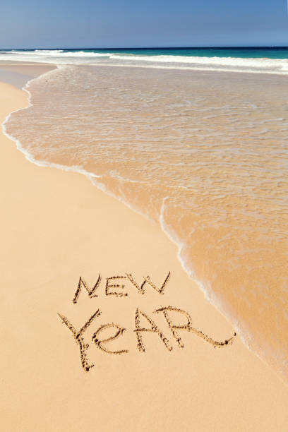 istock Inscription NEW YEAR on sandy beach 1266073380