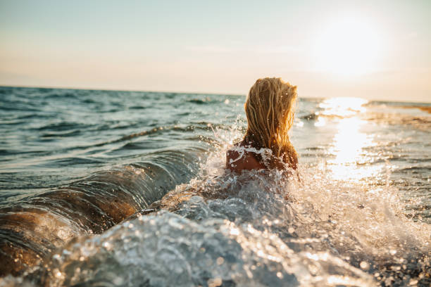 istock Girl having fun in sea during idyllic sunset 1266078254