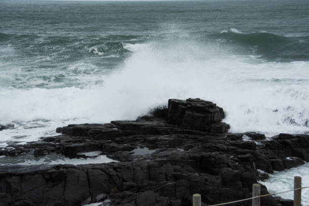 istock Big waves breaking against the rocks 1266086570